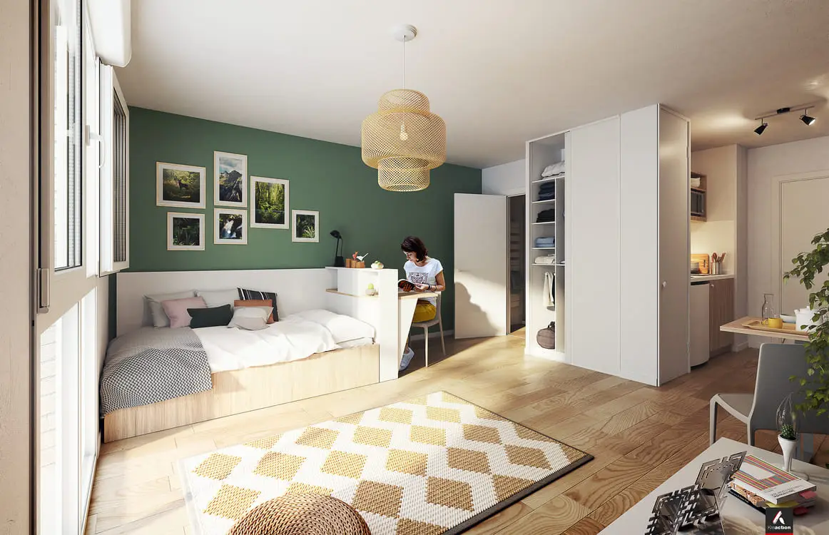 Studio meublé au mur vert, avec lit et coin cuisine