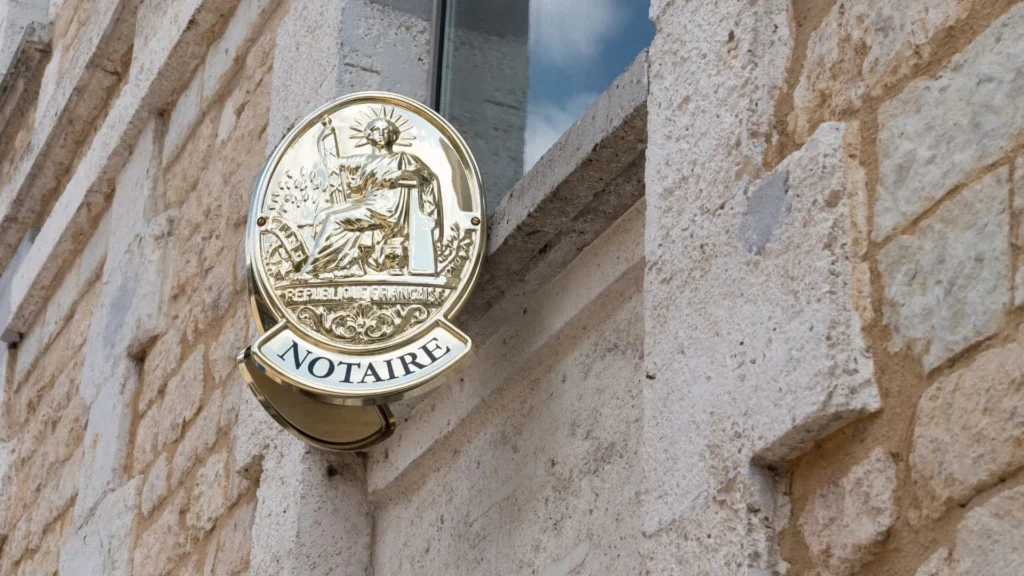 Plaque de notaire sur un mur de pierre