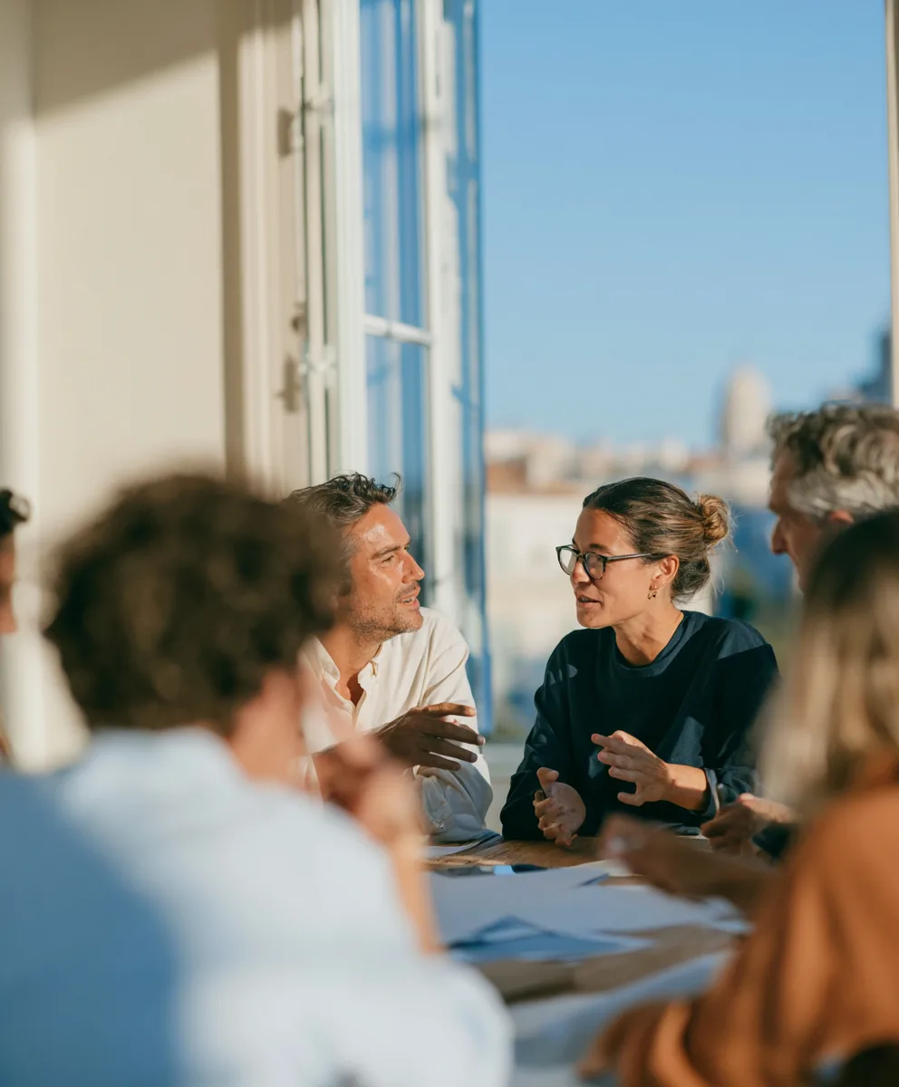 Trois collaborateurs du Cabinet IGC en réunion autour d'une table, dans un bureau lumineux